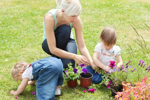 Close-up of hands pruning a shrub with gardening tools in a residential garden